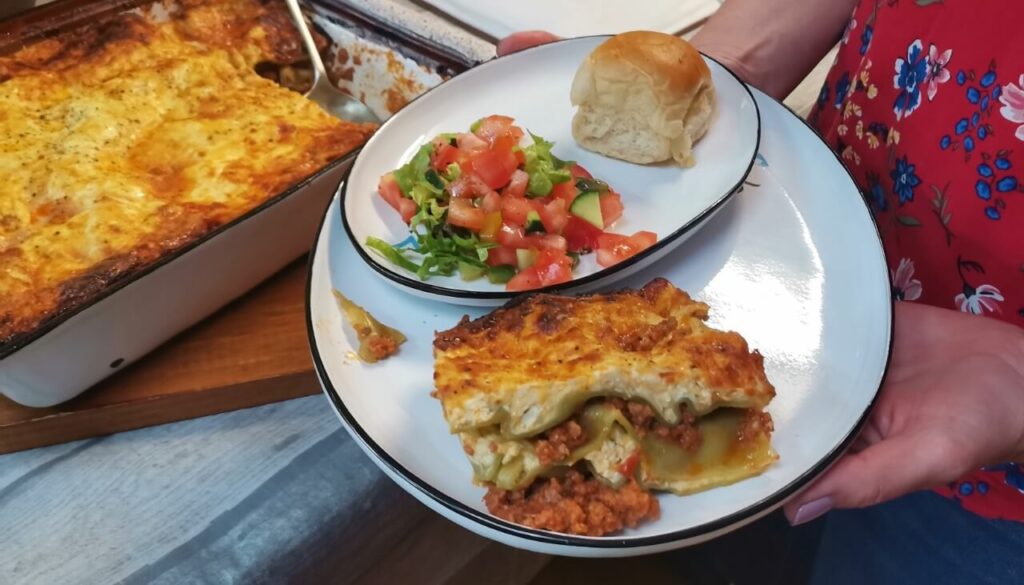 Lasagne with freshly baked roll and salad